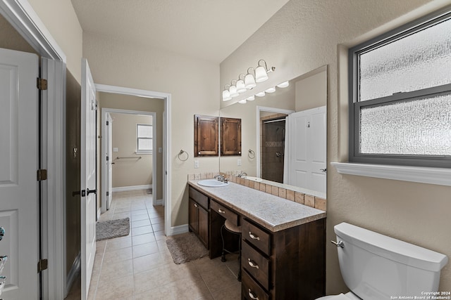 bathroom with tile flooring, toilet, and vanity