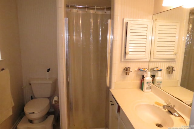 bathroom featuring vanity, toilet, and curtained shower