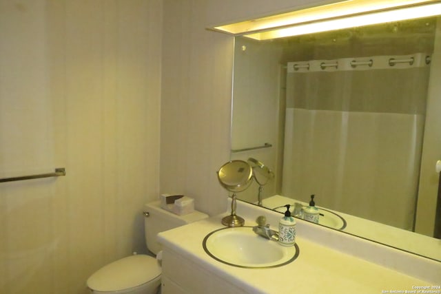 bathroom with vanity, toilet, and curtained shower