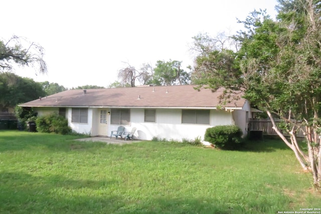 rear view of house featuring a lawn and a patio area