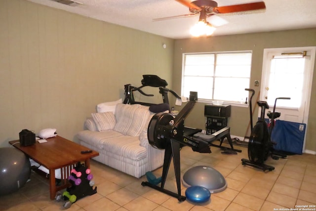 exercise room with ceiling fan and light tile patterned floors