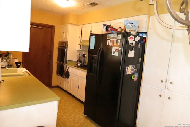 kitchen with black appliances, sink, a textured ceiling, and white cabinetry