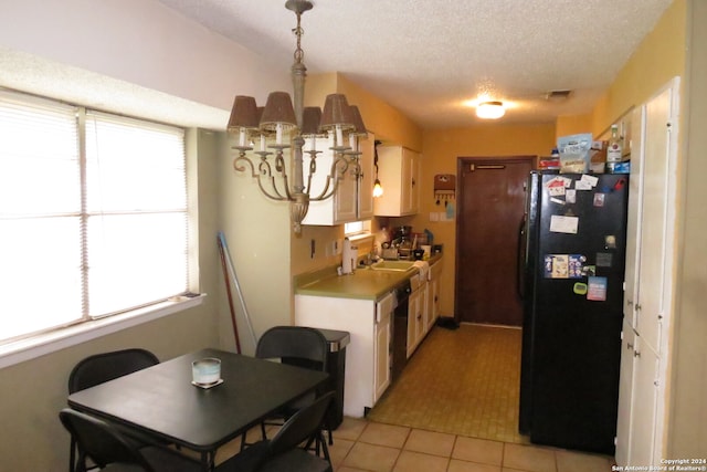 kitchen with black refrigerator, light tile patterned flooring, white cabinetry, decorative light fixtures, and a textured ceiling