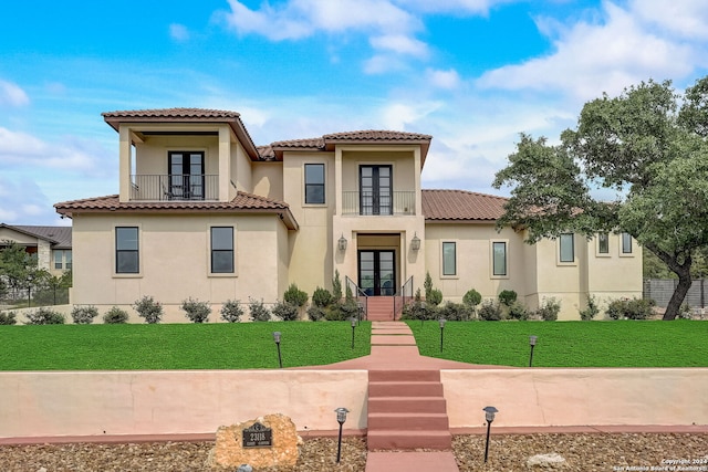 mediterranean / spanish home with a front yard and a balcony