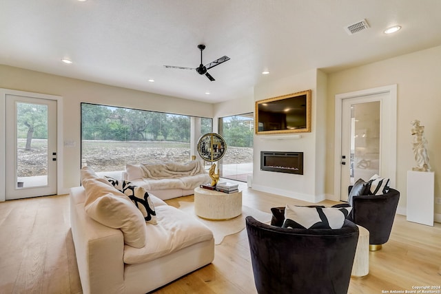 living room featuring ceiling fan and light hardwood / wood-style flooring