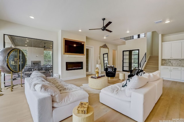 living room with light hardwood / wood-style floors, plenty of natural light, and ceiling fan