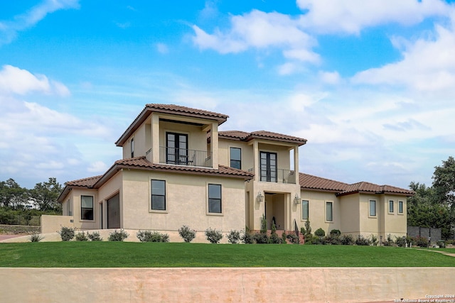 mediterranean / spanish-style house featuring a balcony and a front lawn