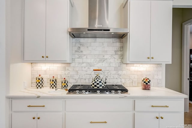 kitchen with backsplash, white cabinets, wall chimney exhaust hood, and stainless steel gas cooktop