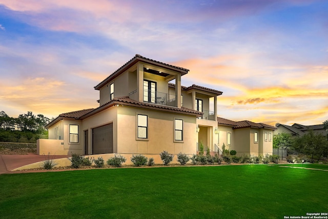 mediterranean / spanish house with a garage, a balcony, and a yard