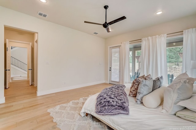 bedroom with ceiling fan, light hardwood / wood-style floors, and multiple windows