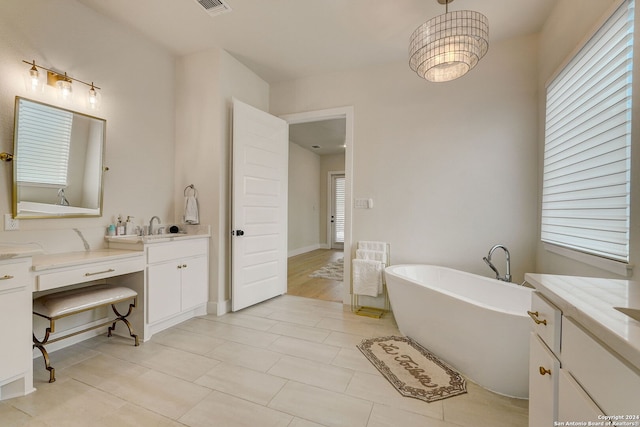 bathroom featuring a tub, vanity, and tile floors