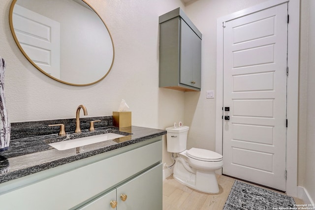 bathroom featuring hardwood / wood-style floors, oversized vanity, and toilet