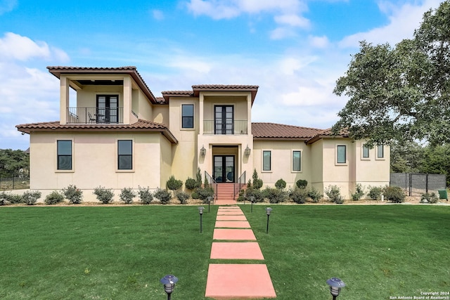 mediterranean / spanish home with a balcony and a front lawn