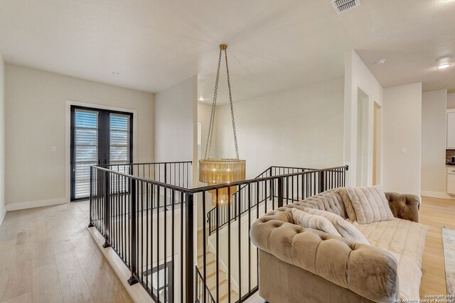 hallway featuring light hardwood / wood-style flooring and an inviting chandelier