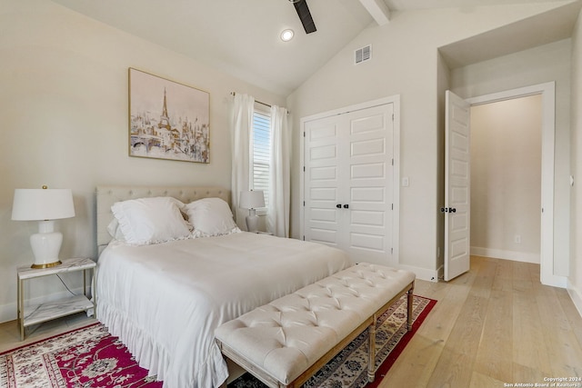 bedroom with a closet, ceiling fan, light hardwood / wood-style flooring, and vaulted ceiling with beams