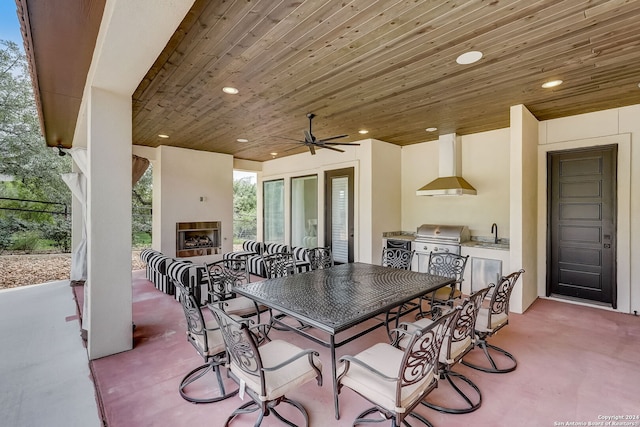 view of patio / terrace featuring a fireplace, a grill, an outdoor kitchen, ceiling fan, and sink