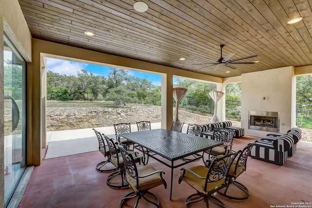 view of terrace featuring ceiling fan and a fireplace