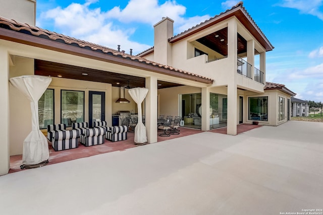 rear view of house featuring a patio, a balcony, and ceiling fan