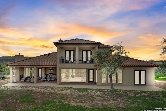 back house at dusk with a patio area