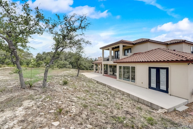 rear view of house featuring a patio and a balcony