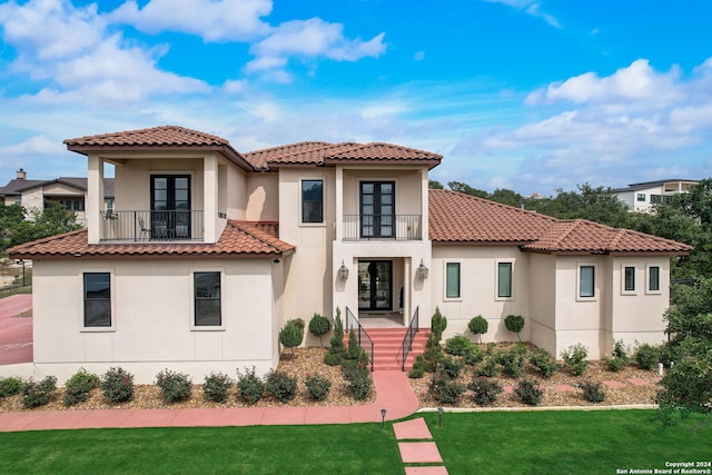 mediterranean / spanish-style home with a front yard and a balcony