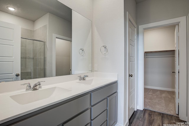 bathroom with vanity, an enclosed shower, and wood-type flooring