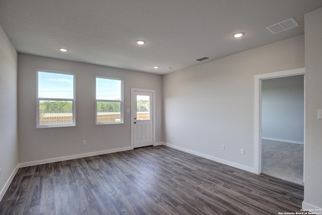 unfurnished room featuring a textured ceiling and dark hardwood / wood-style floors