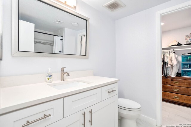 bathroom featuring vanity, toilet, and tile floors