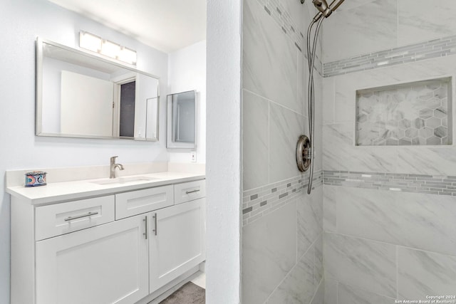 bathroom featuring tiled shower and vanity