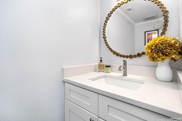 bathroom featuring ornamental molding, a textured ceiling, and vanity