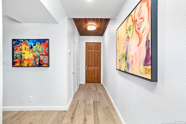 hallway with light hardwood / wood-style flooring and wooden ceiling