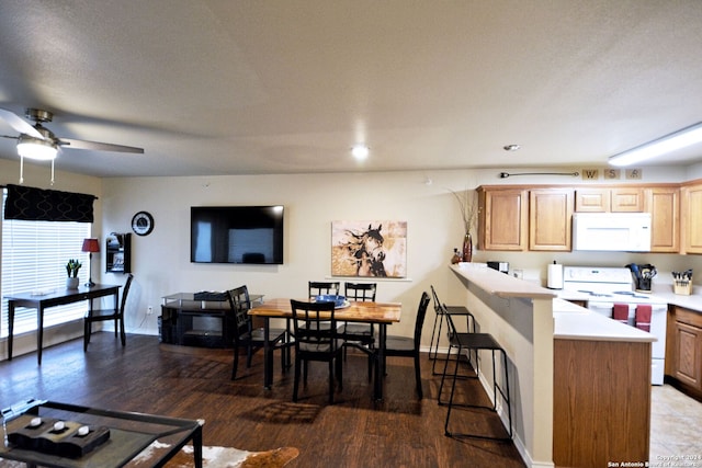 kitchen featuring hardwood / wood-style floors, ceiling fan, white appliances, and a textured ceiling