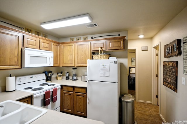 kitchen with tile flooring, sink, and white appliances