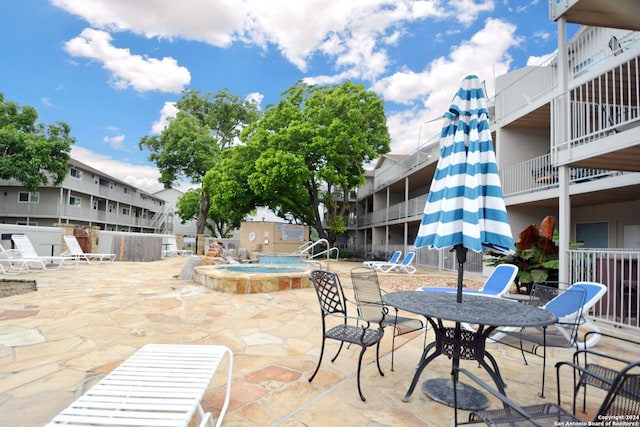 view of terrace with a community hot tub and a balcony