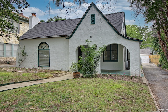 tudor-style house featuring a front lawn