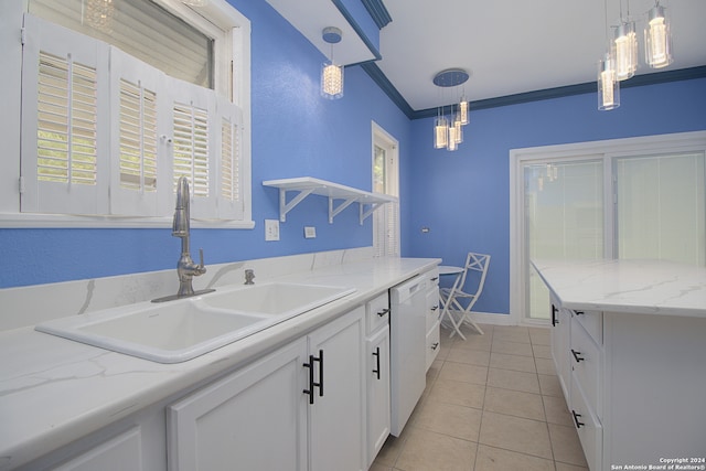 kitchen featuring light tile flooring, a healthy amount of sunlight, white cabinets, sink, and pendant lighting