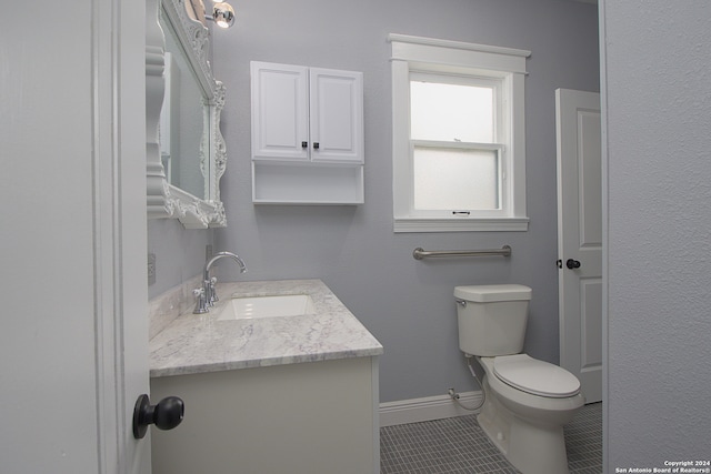 bathroom with vanity, toilet, and tile floors