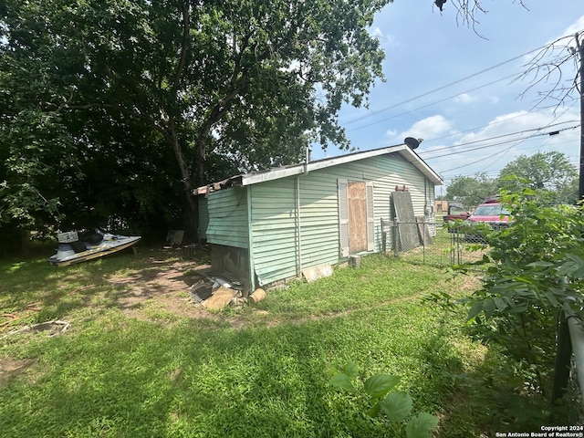 view of side of property with a yard and an outdoor structure