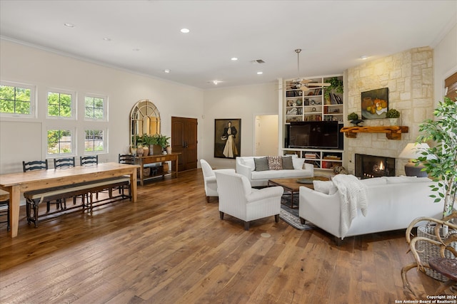 living room with crown molding, a fireplace, and hardwood / wood-style flooring