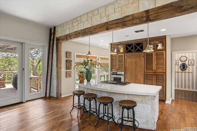 kitchen with stainless steel appliances, a breakfast bar, dark hardwood / wood-style floors, and pendant lighting