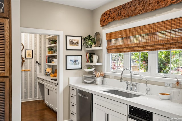 kitchen featuring dishwasher, sink, light stone countertops, and white cabinets