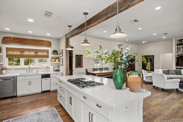 kitchen with stainless steel appliances, wood-type flooring, white cabinets, and a center island