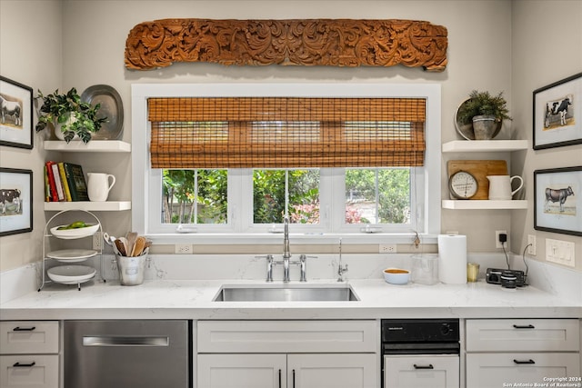 kitchen with white cabinetry, sink, dishwasher, and light stone counters