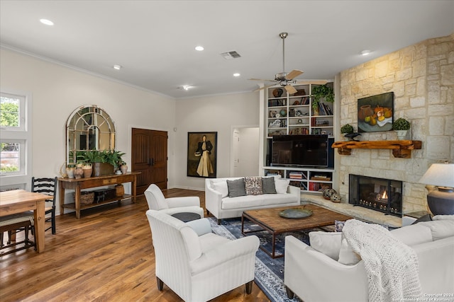 living room featuring a fireplace, ceiling fan, hardwood / wood-style floors, and crown molding