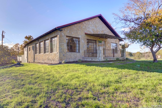 rear view of house featuring a lawn