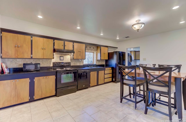 kitchen with sink, backsplash, black appliances, and light tile floors