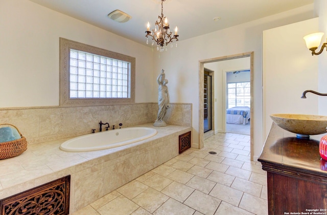 bathroom with tile flooring, sink, and tiled tub