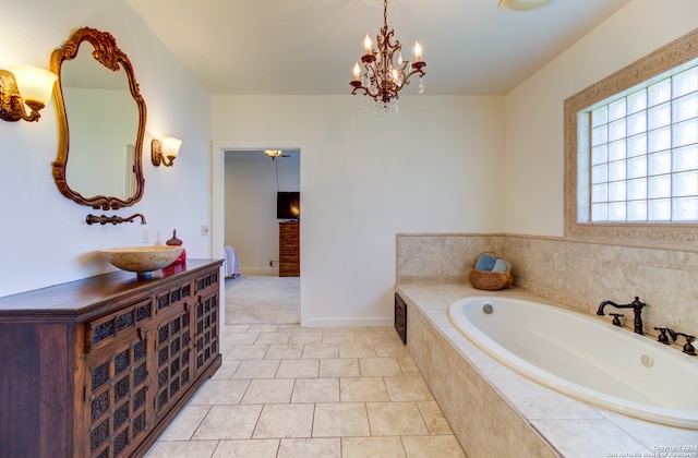 bathroom featuring tile flooring, tiled bath, and vanity