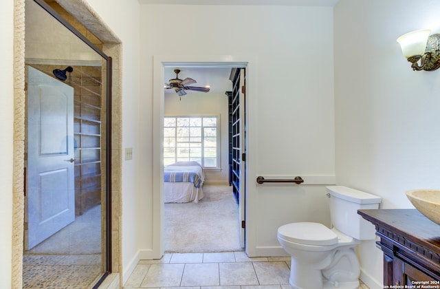 bathroom with ceiling fan, a shower with shower door, tile floors, toilet, and vanity