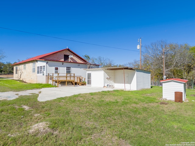 back of house featuring an outdoor structure and a lawn